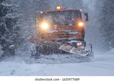 Professional snow plow on a snowy road. Heavy snow and strong wind blowing. Calamity condition.