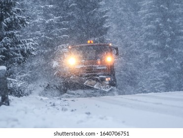 Professional snow plow on a snowy road. Heavy snow and strong wind blowing. Calamity condition.