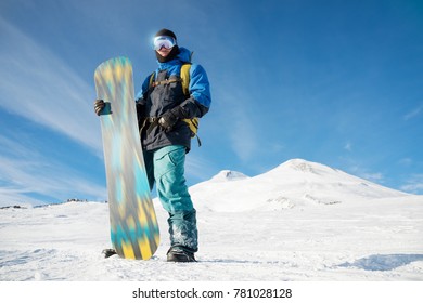 A Professional Snowboarder Stands With His Snowboard