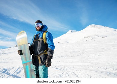 A Professional Snowboarder Stands With His Snowboard