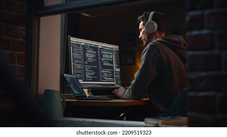 Professional Software Developer Writing Mock-up Code with Basic Programming Language. Program Engineer. Information Technology Specialist. Remote Work Concept. View From Outdoors into Window. - Powered by Shutterstock