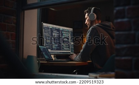 Professional Software Developer Writing Mock-up Code with Basic Programming Language. Program Engineer. Information Technology Specialist. Remote Work Concept. View From Outdoors into Window.