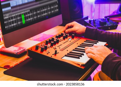 Professional Sound Designer Hands Playing And Tweaking Analog Synthesizer Keyboard Knobs For Editing Sound In Post Production Studio. Sound Design Concept