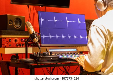 Professional Sound Engineer Recording, Editing, Mixing Voice Over Waveform On Computer In Post Production Studio