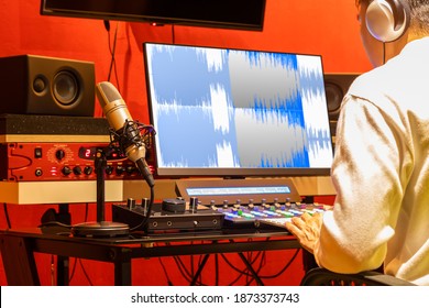 professional sound engineer recording, editing, mixing voice over waveform on computer in post production studio - Powered by Shutterstock