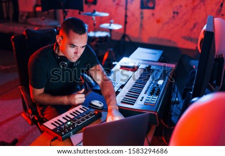 Professional sound engineer working and mixing music indoors in the studio.