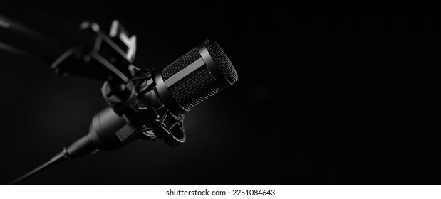 professional sound recording microphone on black background. banner with copy space
