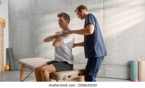 Professional Sport Physiotherapist Working On Specific Muscle Groups And Curing Back Pain With Young Male Athlete. Sportsman Recovering From Mild Injury. Trauma Prevention Therapy And Rehabilitation.