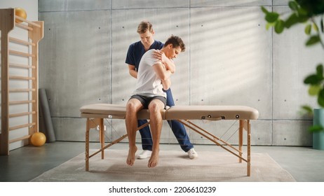 Professional Sport Physiotherapist Working On Muscle Groups And Back Pain With Young Male Athlete. Sportsman Recovering From Mild Injury. Trauma Prevention Therapy Or Rehabilitation.