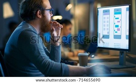 Professional Statistician Works with Graphics on His Personal Computer. In the Background His Colleagues Working.