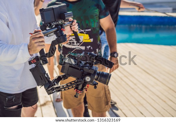 Professional steadicam operator\
uses a 3-axis camera stabilizer system on a commercial production\
set