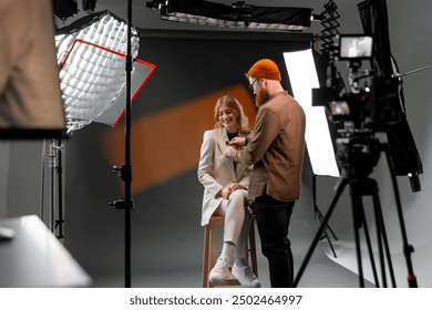 Professional Studio Photoshoot with Female Model and Photographer Adjusting Lighting - Powered by Shutterstock