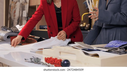 Professional and stylish businesswomen collaborating on fashion design project in modern office space, engaging in dynamic discussion and creative process for innovative fashion ideas - Powered by Shutterstock