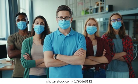 Professional success team of coworkers in open space office. Group portrait multi-ethnic skilled employees with boss crossing arms posing at workspace. Masks. Quarantine. - Powered by Shutterstock