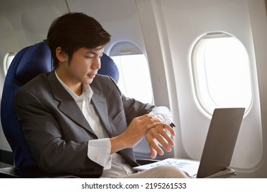 Professional And Successful Asian Businessman Or Male Millionaire Is On His Private Jet, Checking The Time On His Modern Luxury Smart Watch.