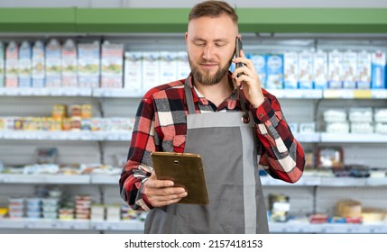 Professional Supermarket Clerk Using A Touch Screen Tablet And Working, Smiling At Camera, Supermarket Worker Ordering Goods By Phone, Man Food Store Assistant At Work, Retail Concept