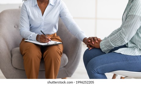 Professional support for people with mental problems. Therapist providing psychological help to female patient, holding her hand at clinic, closeup. Treatment of emotional and mood disorders