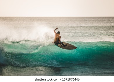 professional surfer riding waves in Bali, Indonesia. men catching waves in ocean, isolated. surfing at sunset 