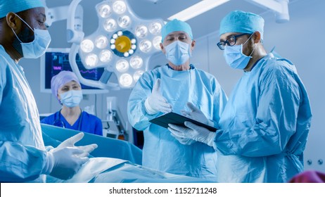Professional Surgeons and Assistants Talk and Use Digital Tablet Computer During Surgery. They Work in the Modern Hospital Operating Room. - Powered by Shutterstock