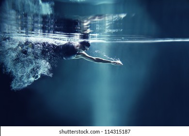 professional swimmer crawl underwater isolated blue background