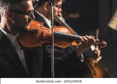 Professional Symphonic Orchestra Performing On Stage And Playing A Classical Music Concert, Violinist Playing In The Foreground, Arts And Entertainment Concept