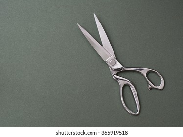 Professional Tailor Scissors On Green Background