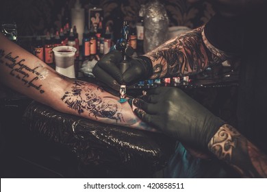 Professional tattoo artist makes a tattoo on a young girl's hand.  - Shutterstock ID 420858511