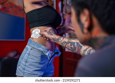 Professional tattoo master man shows sketches on paper to the customer. Discussion tattoos in work. - Shutterstock ID 2159292271