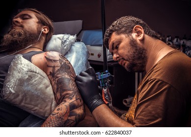 Professional Tattooist Working Tattooing In Tatoo Salon./Professional Tattooer Makes Tattoo In Tattoo Parlor.