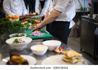 Professional Team Cooks And Chefs Preparing Meal At Busy Hotel Or Restaurant  Kitchen