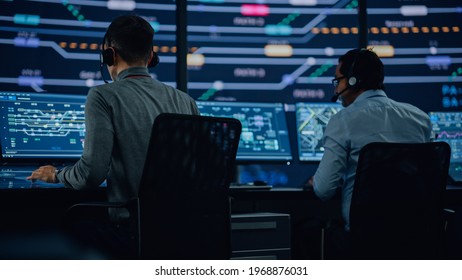 Professional IT Technical Support Specialists and Software Programmer Working on Computers in Monitoring Control Room with Digital Screens with Server Data, Blockchain Network and Surveillance Maps.