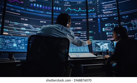 Professional IT Technical Support Specialists and Software Programmer Working on Computers in Monitoring Control Room with Digital Screens with Server Data, Blockchain Network and Surveillance Maps. - Shutterstock ID 1968876070