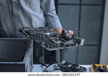Professional technician or engineer repairing or assembling electronic computer PC equipment.
