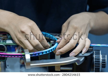professional technician performing stringing service for badminton racket