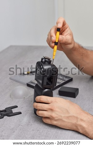 professional technician repairs a camera flash. Photographic equipment service. repairs photo flash, speedlight