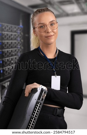 Professional IT technician working in a secure data center environment holding a network switch component.