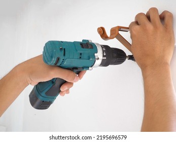 Professional technicians installing window curtain rod on the wall. Closeup photo, blurred.