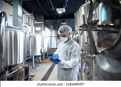 Professional technologist using tablet in production plant checking productivity and quality. - Powered by Shutterstock