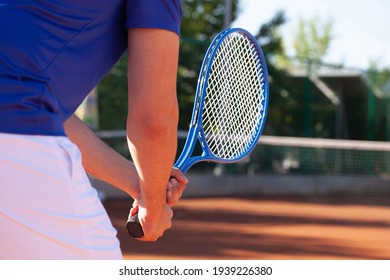 Professional tennis player holding a tennis racket in two hands in an expectation of the service of the opponent