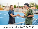 Professional tennis players shaking hands at the end of a tennis game on outside court. High quality photo