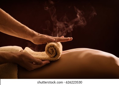 A professional therapist applies a hot towel on the back of a man. Hot towel compress. SPA treatment - Powered by Shutterstock