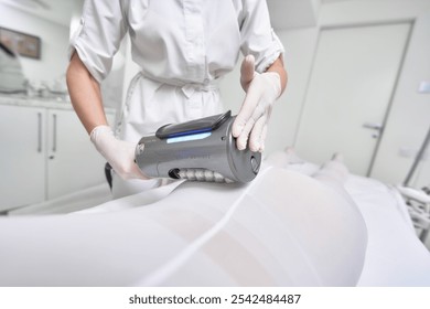 Professional therapist performing body contouring treatment in clinic - Powered by Shutterstock