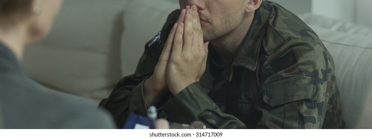 Professional therapist working with young soldier suffering from PTSD - Shutterstock ID 314717009