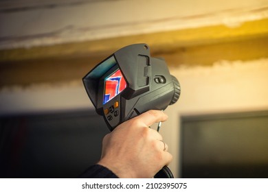 Professional thermal imager in hand. Close-up study of the object with an infrared camera. Heat leaks