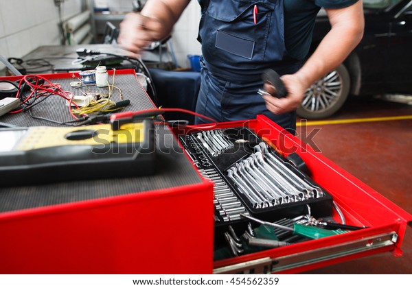 Professional\
toolbox with modern tools at garage. Mechanic taking facilities\
from special box for mechanical\
instruments