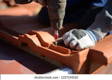 Professional Training In Roofing Trade: The Job Is Building Roofs With Red Tiles, Light Working Glove In Background