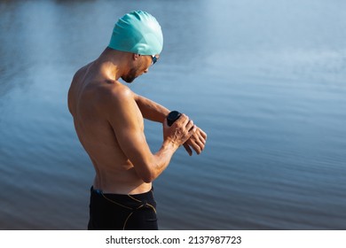 Professional Triathlete Before Swimming In River's Open Water. Man Wearing Swim Equipment Practicing Triathlon On The Beach In Summer's Day. Concept Of Healthy Lifestyle, Sport,