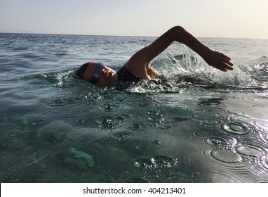 Professional Triathlete Practicing In Open Water. Swimming In Sea. Triathlon Training In Wetsuit.