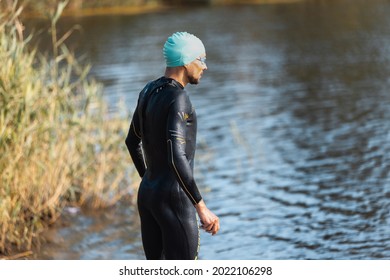 Professional Triathlete Swimming In River's Open Water. Man Wearing Swim Equipment Practicing Triathlon On The Beach In Summer's Day. Concept Of Healthy Lifestyle, Sport, Action, Motion And Movement.