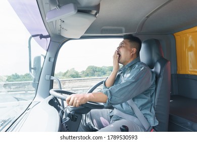 Professional Truck Driver, Adult Male, Safety Belt Yawning And Sleepy. Young Man Worker Is Confident In The Safety Of The Transport And Delivery Business For A Long Time.